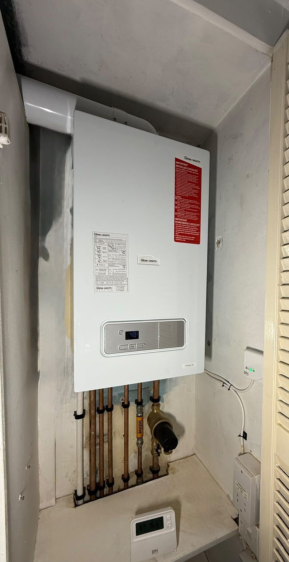 Glow-worm boiler fitted in a cupboard with copper pipework