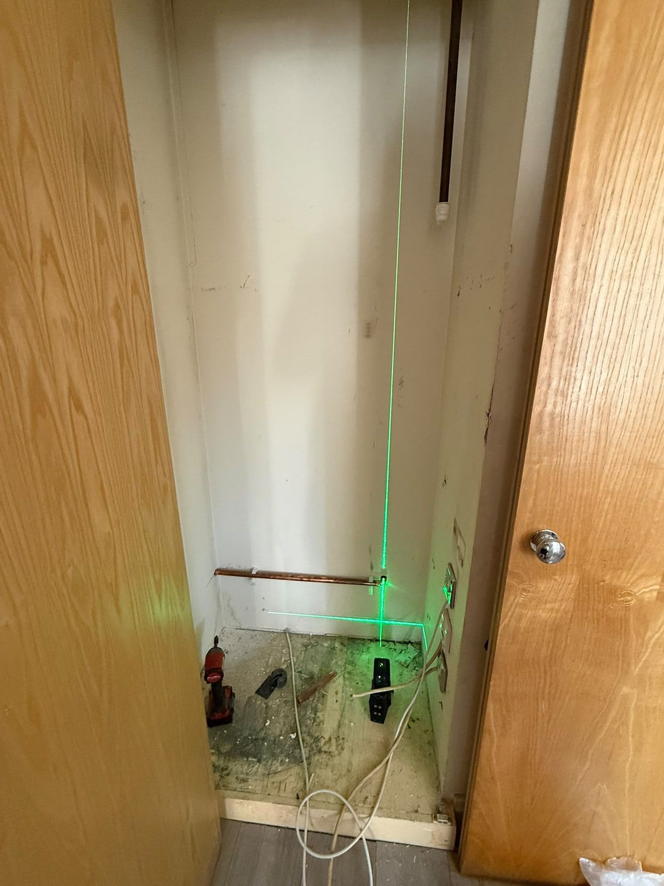 Empty cupboard being set out with a laser level