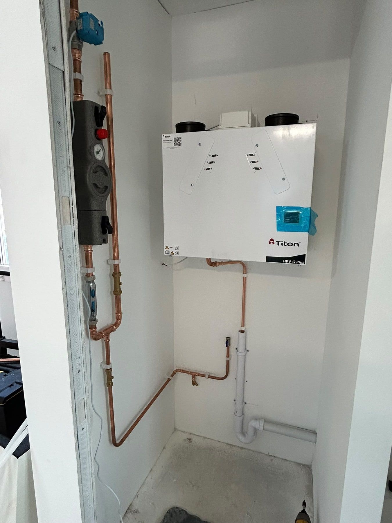 Heat interface unit with copper pipes in a freshly painted cupboard