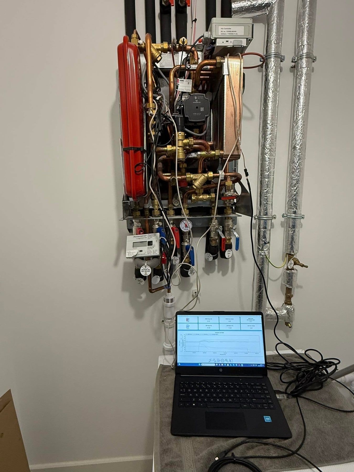 Laptop connected to a heat interface unit, showing its data