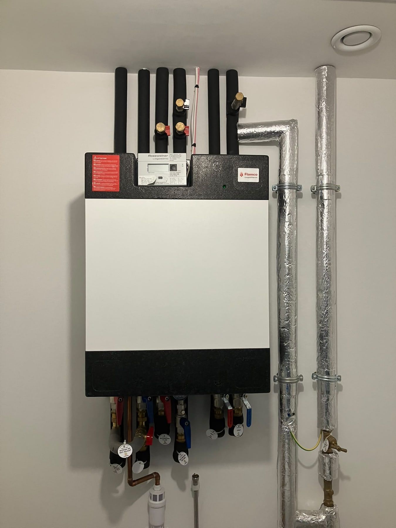 Heat interface unit below insulated flow and return pipes