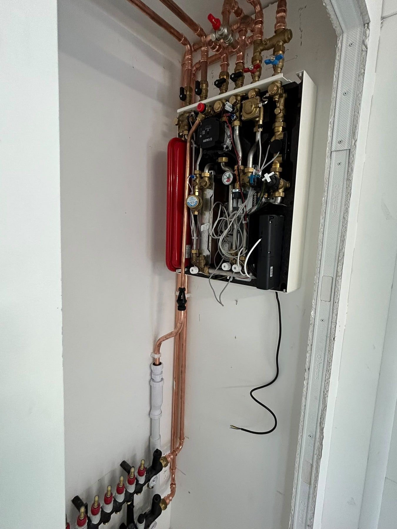 Heat interface unit with the cover off, showing valves and expansion vessel